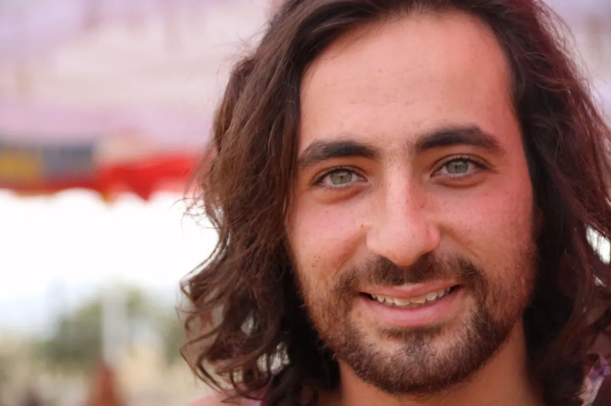 ניב איפרגן עם שיער ארוך וזקן, מחייך, לפני שהפסיק לעשן